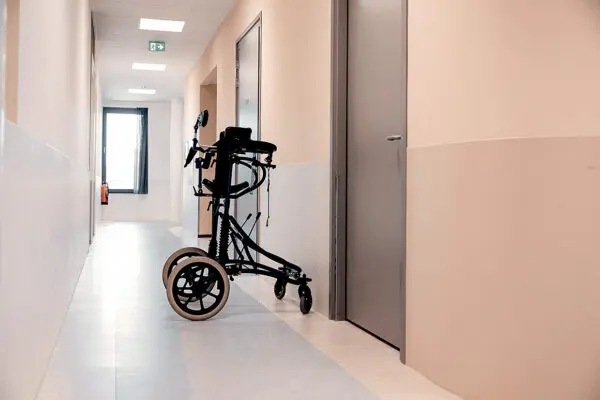 Rollator staat op de gang van een instelling voor een deur