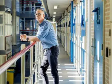 Afbeelding van Martijn Ruiten die zich bevindt in de gang van een cellencomplex in PI Leeuwarden