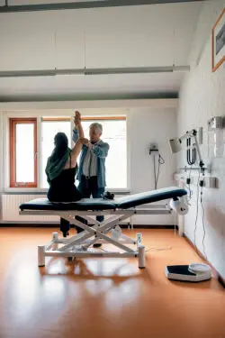 Fotos van huisarts die vrouw onderzoekt op onderzoektafel