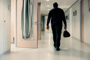 Foto van huisarts die door de gang van een PI loopt met dokterstas in de hand