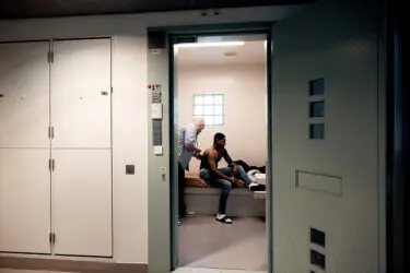 Foto van huisarts die een gedetineerde in cel onderzoekt