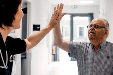 Huisarts shakes hands met verstandelijk gehandicapte in zorghuis