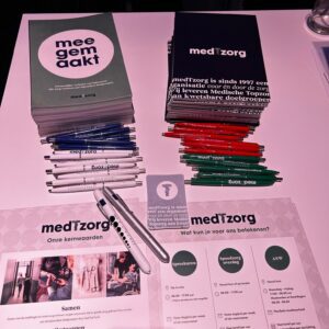 Flyers en gadgets liggen op een statafel op de LHV Startersdag beurs voor huisartsen