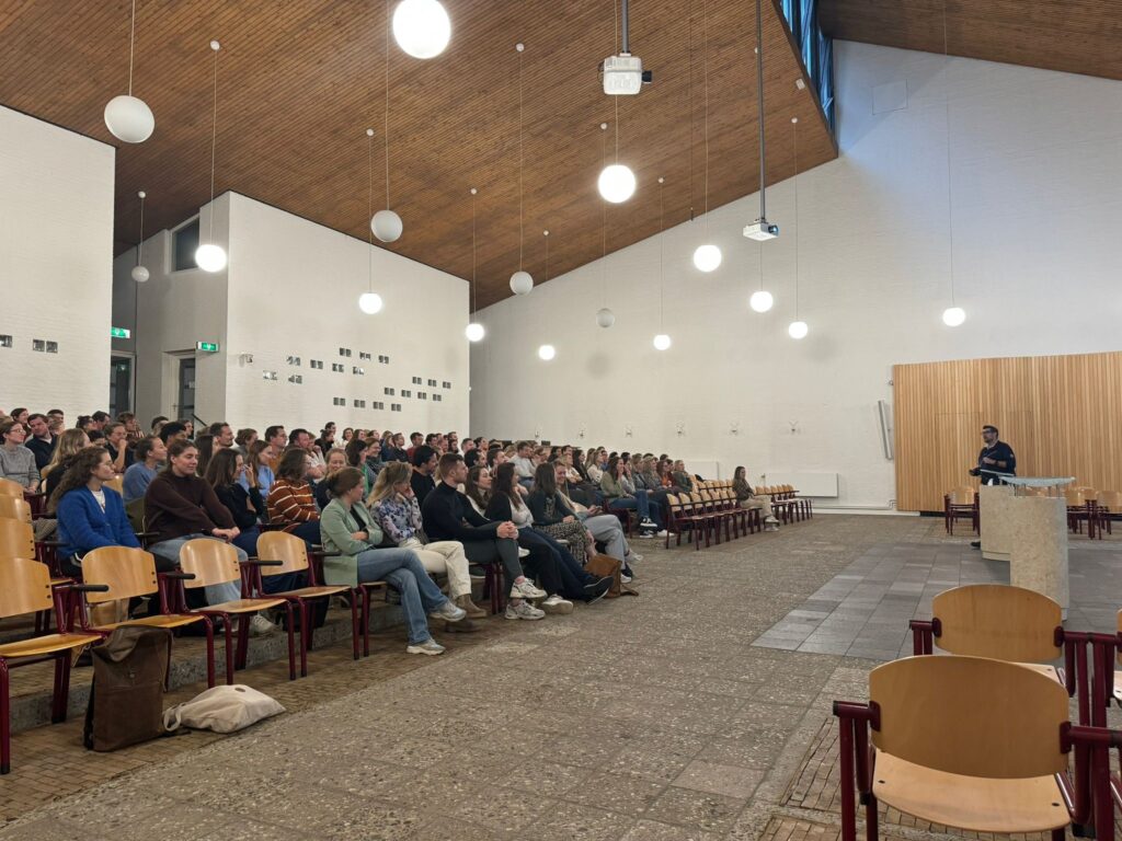 Tim Peeters presenteert voor een volle zaal huisartsen in de Boskapel te Nijmegen over het werken als huisarts in een PI