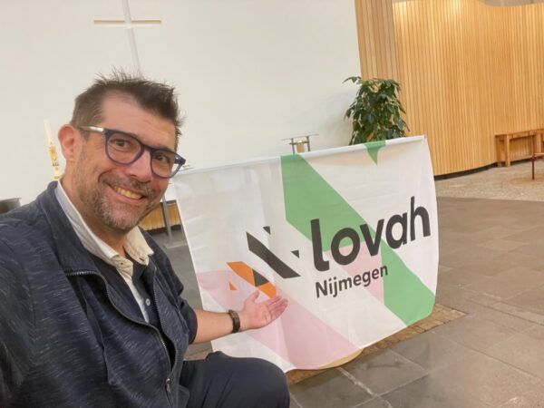 Tim Peeters op de voorgrond met een LOVAH vlag tijdens het symposium in Nijmeten