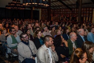 Foto van de zaal met 150 mensen luisterend tijdens het congres Achter de casus