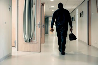 Foto van huisarts die door de gang van een PI loopt met dokterstas in de hand