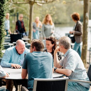 Afbeelding collega's medTzorg bij elkaar aan tafel buiten