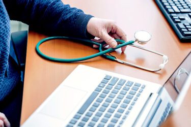 Foto van laptop en stethoscoop