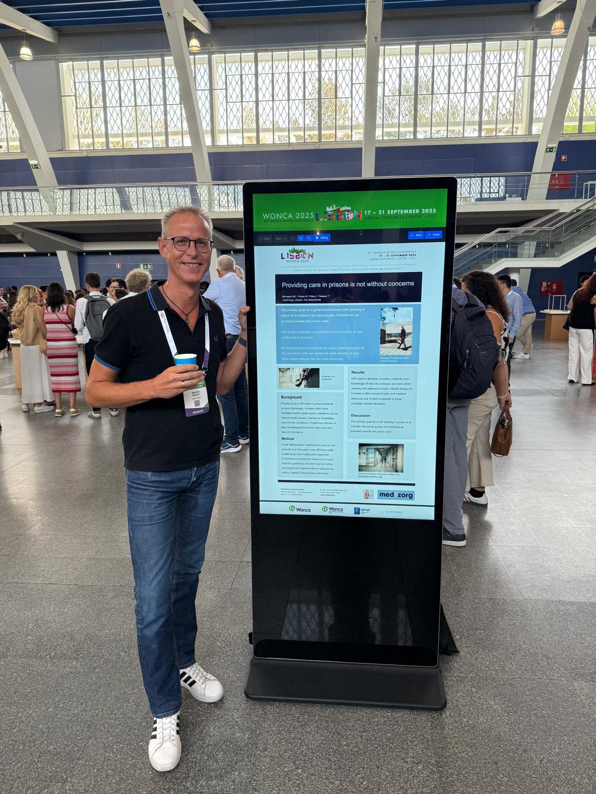 Foto van Martijn Ruiten bij een posterzuil tijdens WONCA Congres