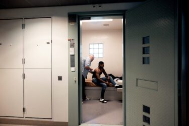 Foto van huisarts die een gedetineerde in cel onderzoekt